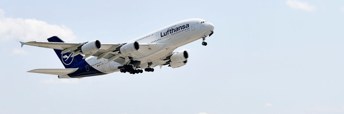 lufthansa-a380-flughafen-muenchen Ein Lufthansa-Flugzeug hebt ab und fliegt in den blauen Himmel mit wenigen Wolken.