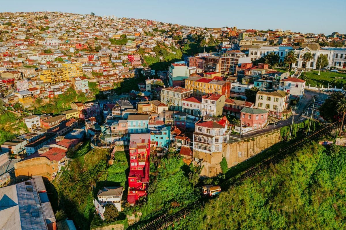 Luftaufnahme der dicht bebauten, farbenfrohen Hügelstadt Valparaíso in Chile mit zahlreichen Häusern, die sich eng an die steilen Hänge schmiegen.