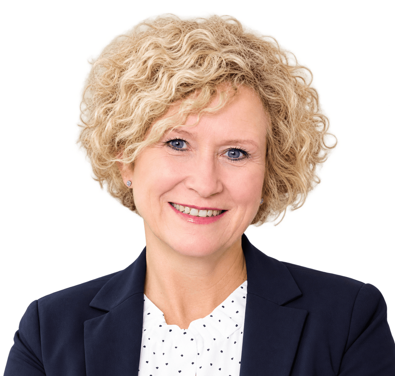 Aust Birgit Porträt einer blonden Frau mit lockigem Haar, die ein weißes Hemd mit kleinen schwarzen Punkten und einen dunkelblauen Blazer vor schwarzem Hintergrund trägt.