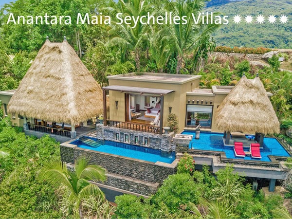 Eine luxuriöse Villa mit zwei strohgedeckten Pavillons und einem privaten Infinity-Pool, eingebettet in eine üppige tropische Vegetation auf den Seychellen.