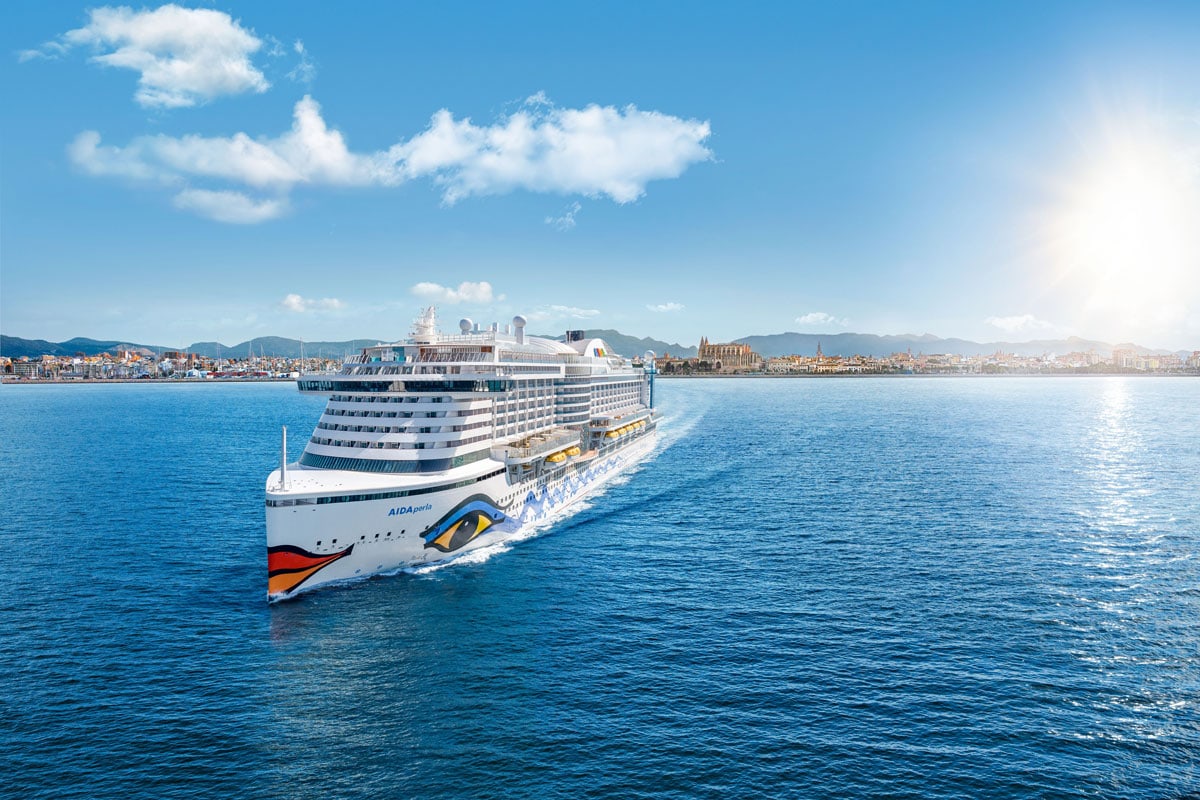 Das Kreuzfahrtschiff AIDAperla fährt auf dem blauen Meer vor der Küste von Palma de Mallorca bei strahlendem Sonnenschein und klarem, blauem Himmel.